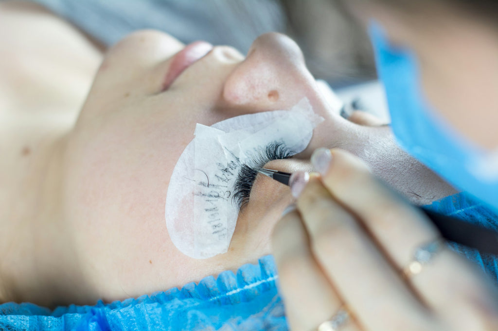 Technicienne posant des extensions de cils (photo d'ambiance)